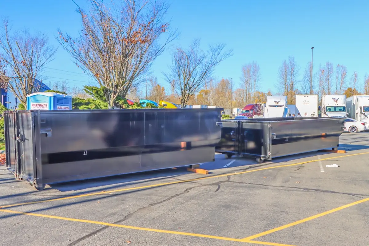 Professional dumpster rental service with roll-off container on residential driveway in Harrietstown
